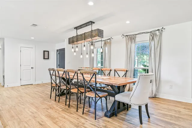 a dining hall with stainless steel appliances granite countertop a refrigerator and a stove top oven