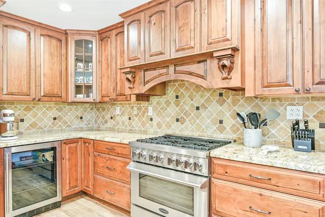 a kitchen with stainless steel appliances granite countertop a table chairs sink refrigerator and cabinets