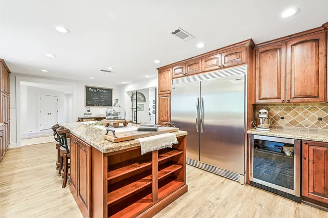a dining hall with stainless steel appliances a dining table chairs and kitchen view