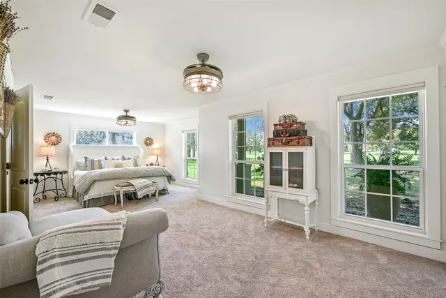 a view of a hallway to room with wooden floor and windows