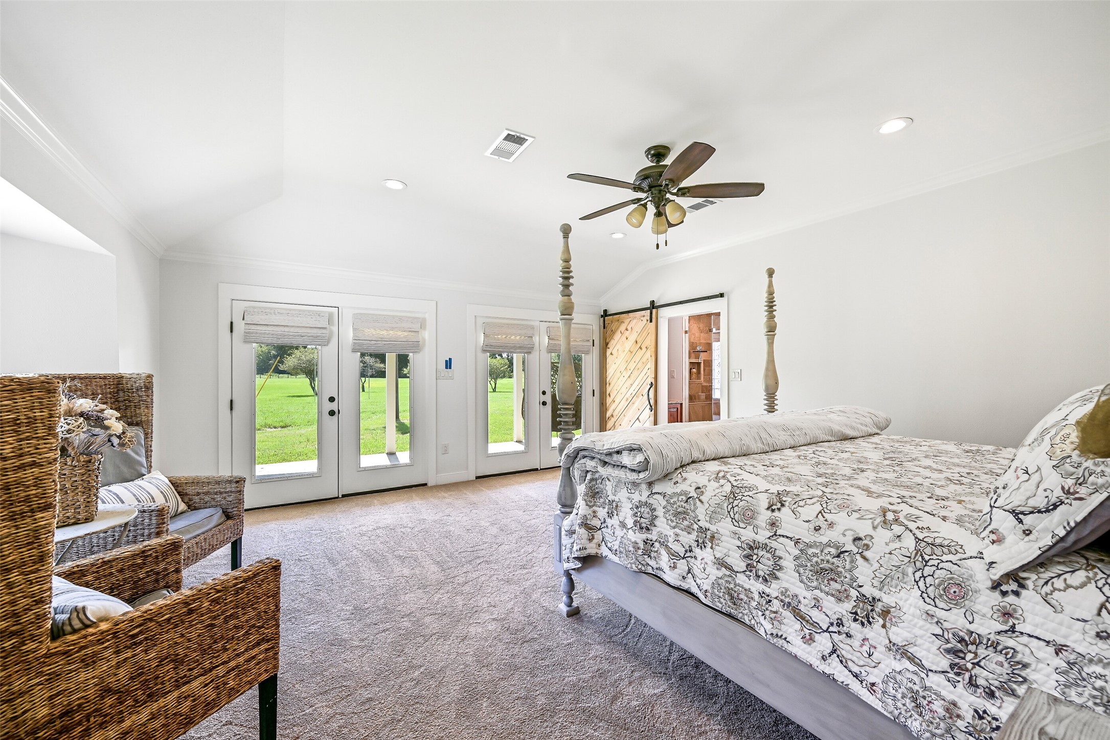 3042 Poskey Road Anahuac, TX 77514 - Photo 33 of 50 Luxurious primary suite with an elegant four-poster bed and double doors opening to a private patio.