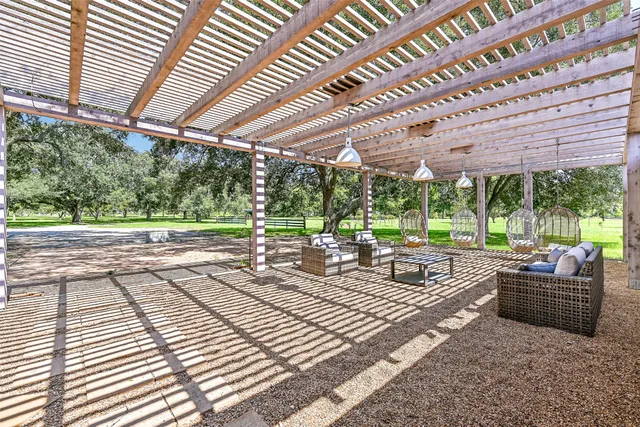 a view of a patio with couches chairs and wooden floor