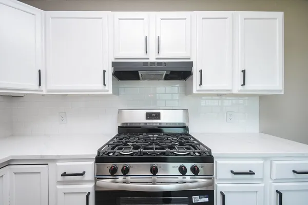 a stove top oven sitting inside of a kitchen