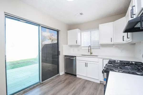 a kitchen with a sink a refrigerator and white cabinets