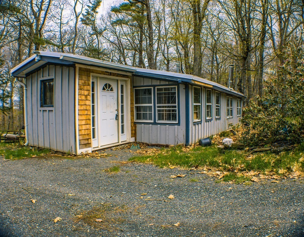a view of a house with a yard and large tree