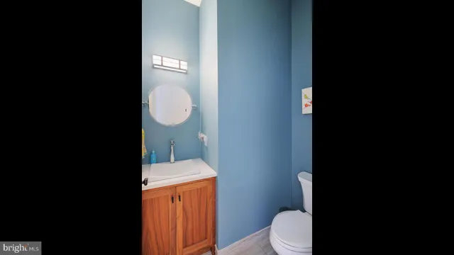 a bathroom with a granite countertop toilet and a sink