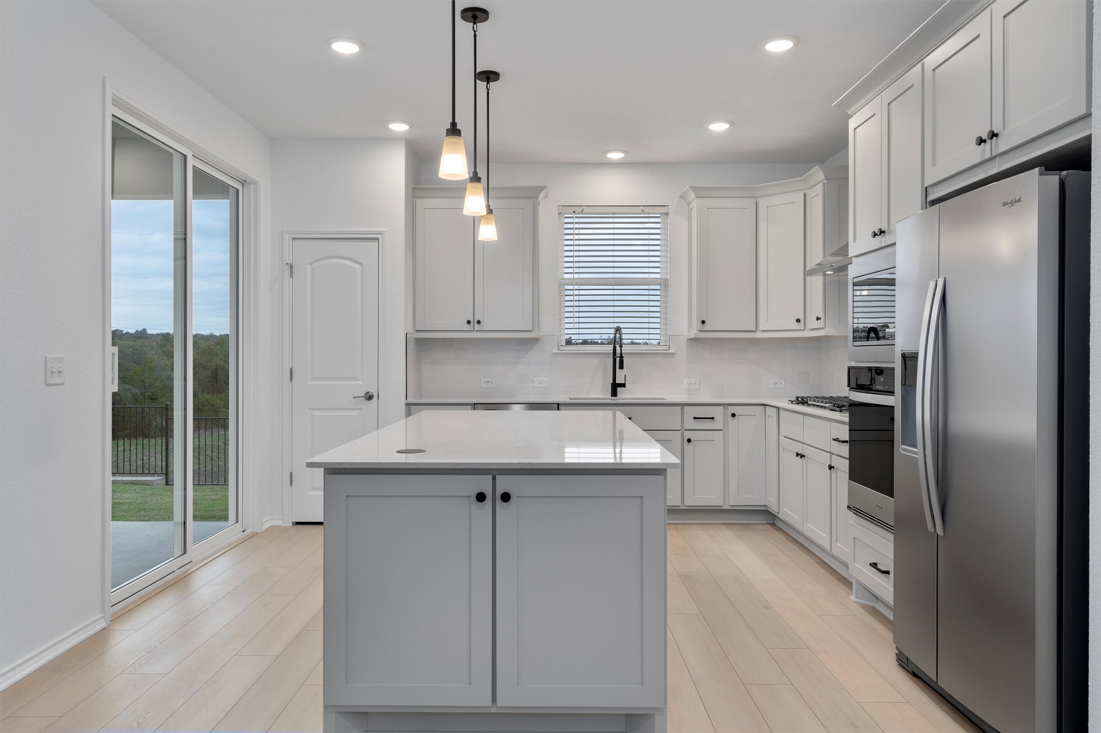 a kitchen with stainless steel appliances granite countertop a sink a stove a refrigerator and cabinets