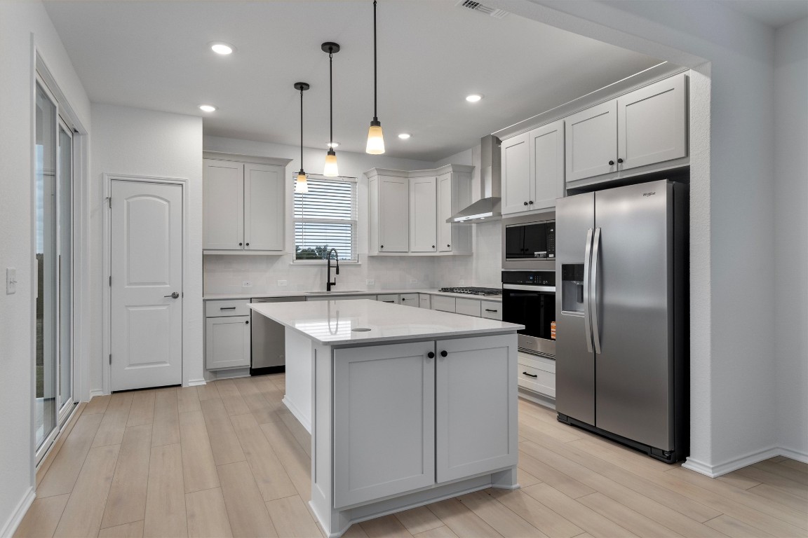 310 Livewater Lane Georgetown, TX 78633 - Photo 13 of 33 a kitchen with stainless steel appliances granite countertop a refrigerator a sink a stove and a oven