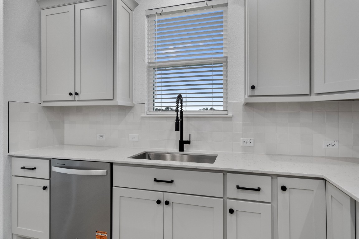310 Livewater Lane Georgetown, TX 78633 - Photo 15 of 33 a kitchen with white cabinets and a sink