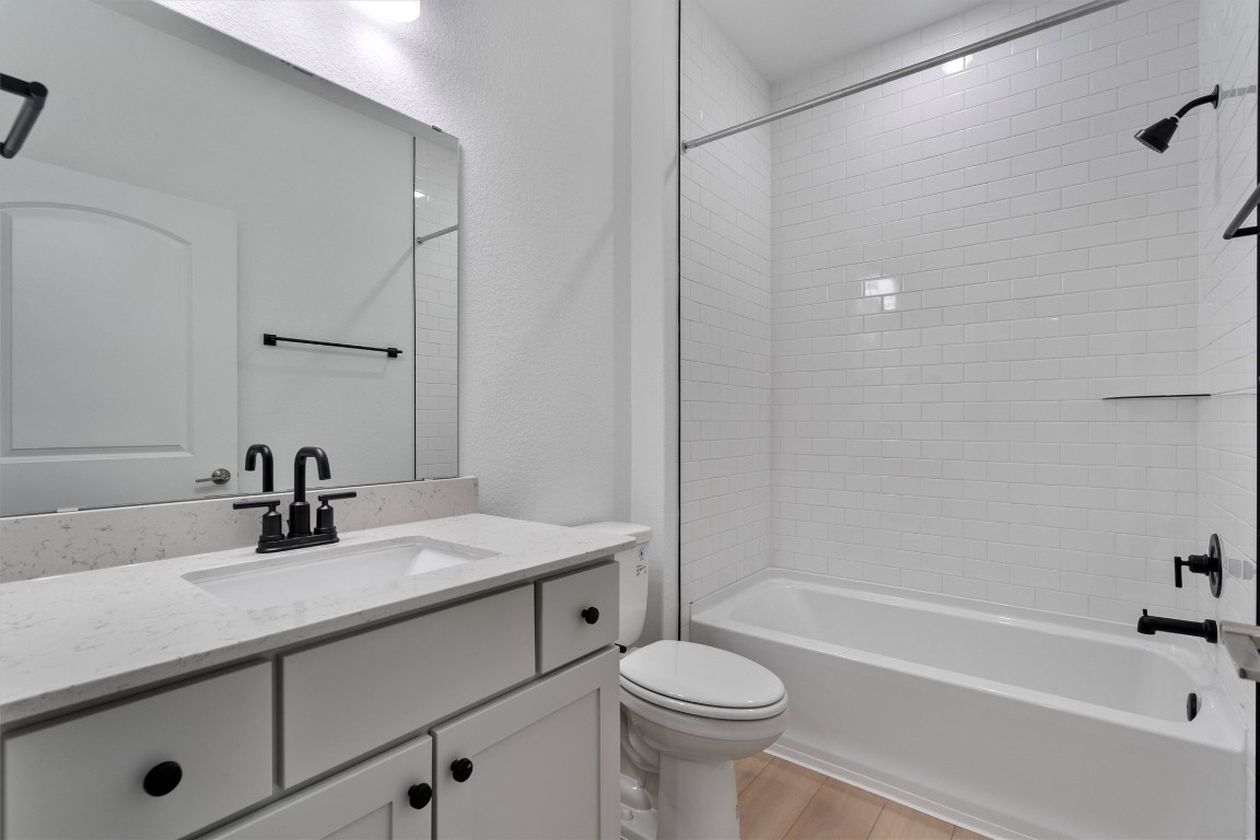 310 Livewater Lane Georgetown, TX 78633 - Photo 26 of 33 a bathroom with a sink a toilet a mirror a bathtub and shower