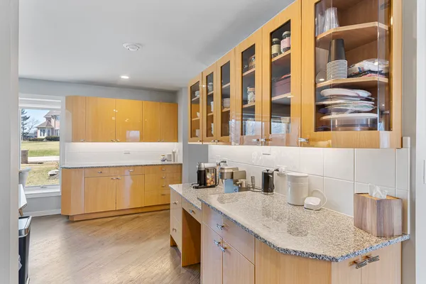 a large white kitchen with wooden floor and a sink