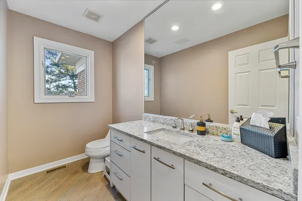 a view of a hallway with wooden floor and a living room