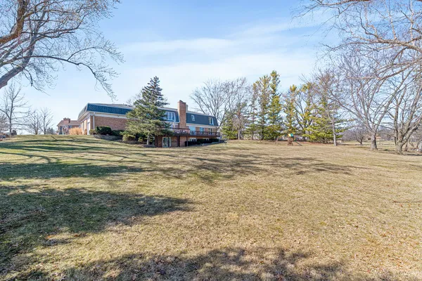 a view of a large building next to a road with large trees