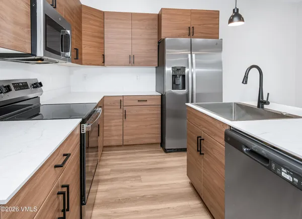 a kitchen with cabinets a sink and appliances