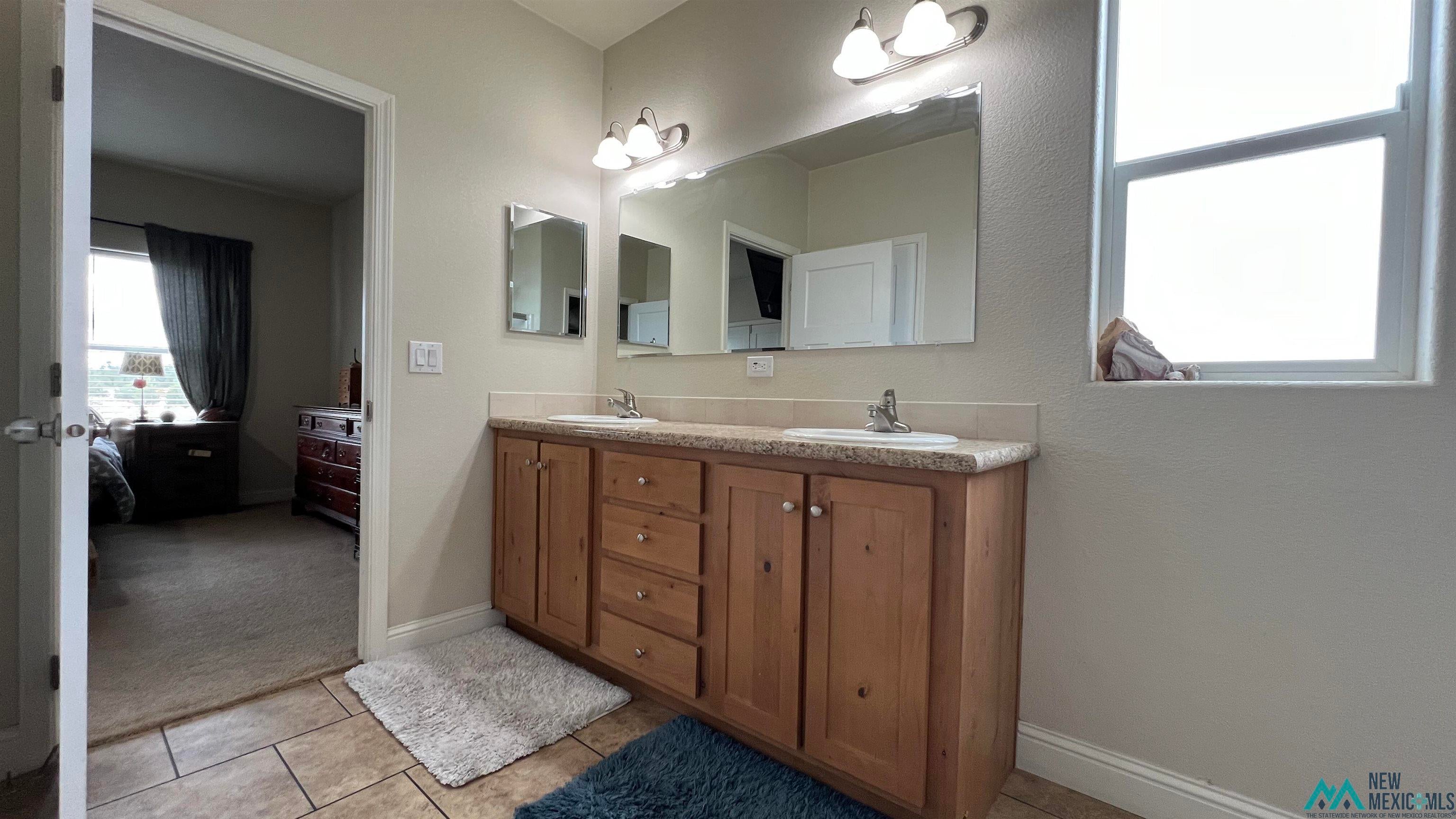 56 Kachina Road Quemado, NM 87829 - Photo 17 of 36 Ensuite bathroom with double vanity and light tile patterned floors