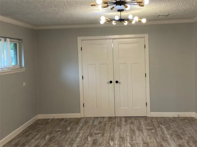 a view of a chandelier fan and hardwood floor
