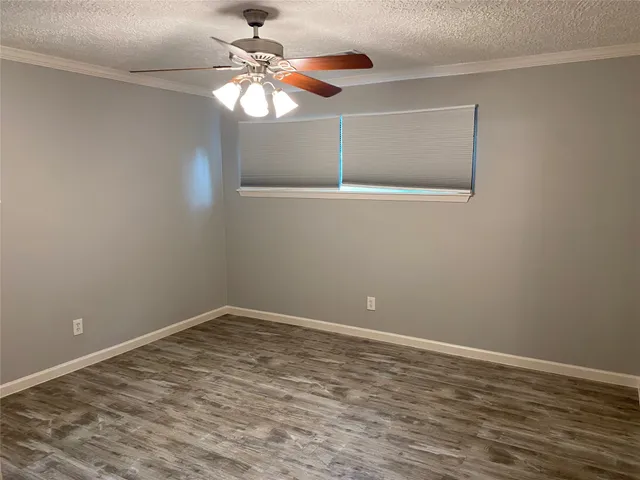 a view of a room with wooden floor and fan