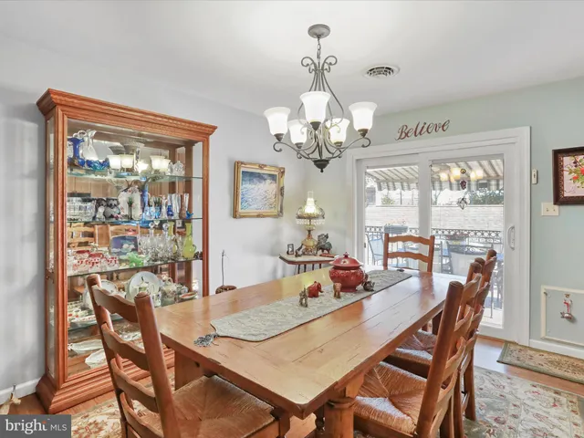 a view of a dining room with furniture a chandelier and wooden floor