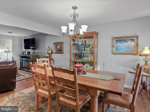 a view of a dining room with furniture a chandelier and wooden floor