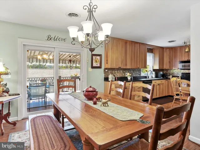 a view of a dining room with furniture a chandelier and wooden floor
