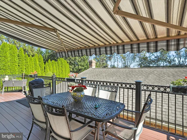 a view of a patio with table and chairs with wooden floor and fence