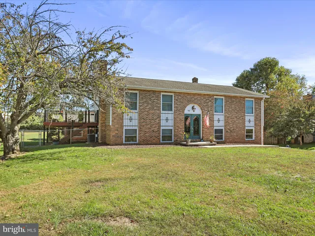 a front view of a house with a garden and trees