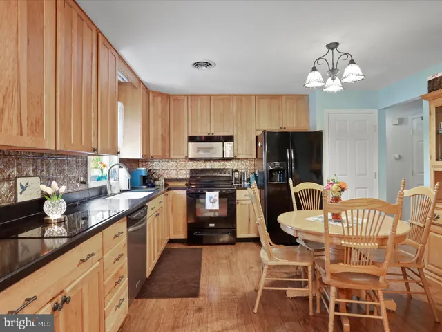 a kitchen with a dining table chairs stainless steel appliances and cabinets