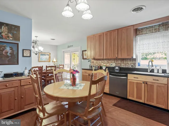 a kitchen with a dining table chairs and white cabinets