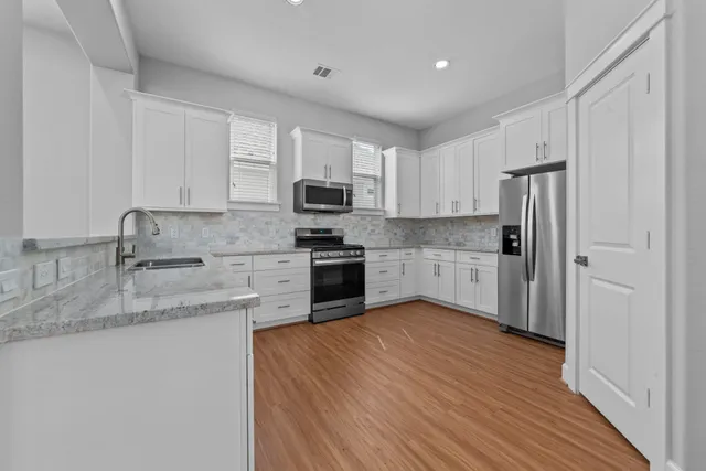a kitchen with stainless steel appliances granite countertop a refrigerator sink and cabinets