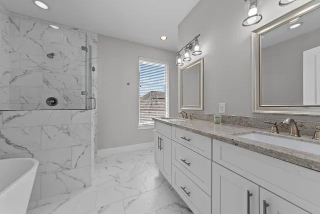 a bathroom with a granite countertop sink a toilet a mirror and shower