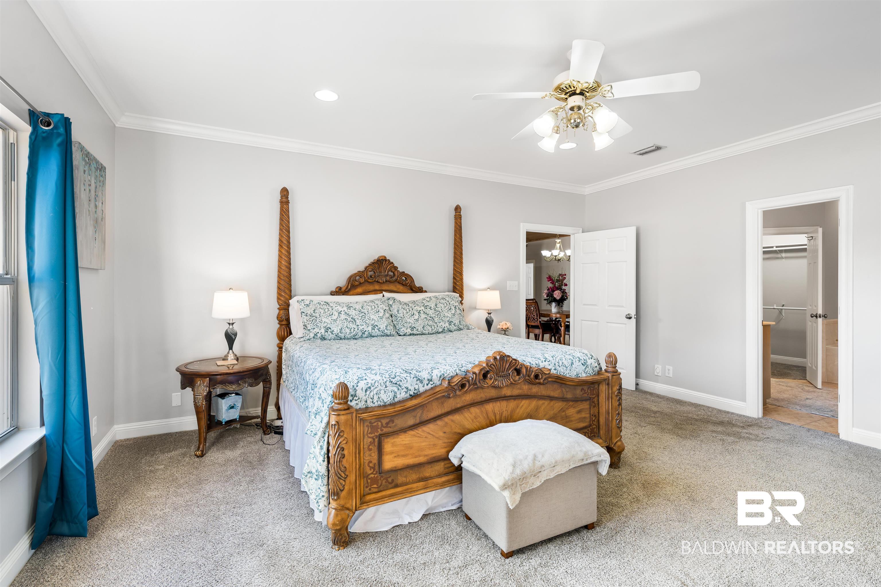19079 Baldwin County Road 10 Foley, AL 36535 - Photo 19 of 37 Bedroom with light colored carpet, crown molding, ceiling fan, and hanging lights
