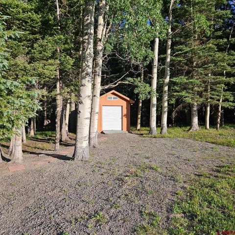 a view of a house with backyard and tree