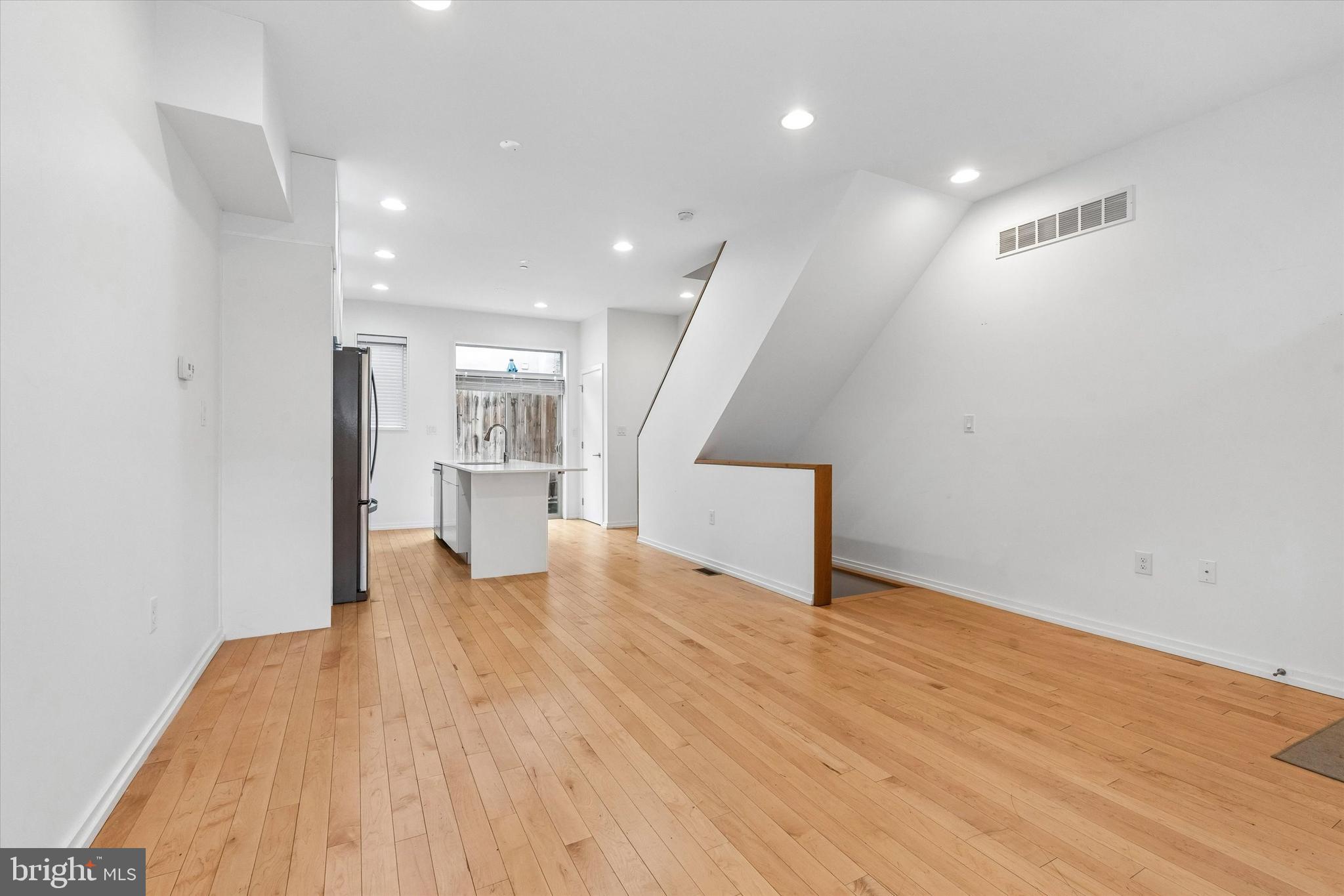 936 North Leithgow Street Philadelphia, PA 19123 - Photo 4 of 40 a view of an empty room with wooden floor and a kitchen