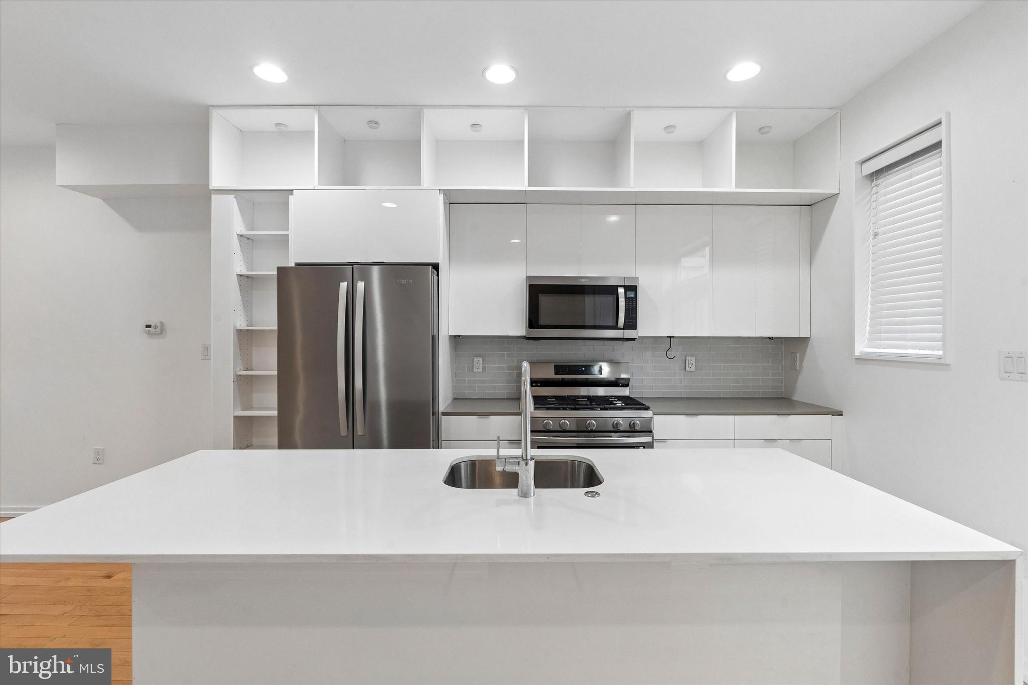 936 North Leithgow Street Philadelphia, PA 19123 - Photo 6 of 40 a kitchen with stainless steel appliances a refrigerator a stove a sink and white cabinets