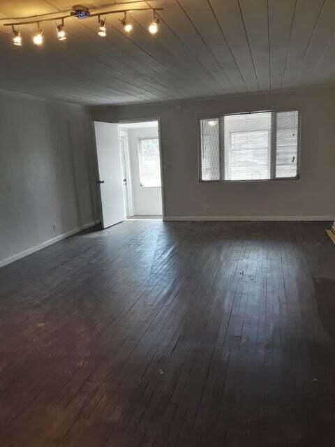 1340 West 33rd Street Riviera Beach, FL 33404 - Photo 2 of 11 a view of an empty room with wooden floor and a window