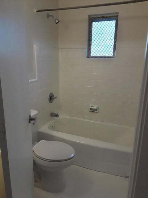 1340 West 33rd Street Riviera Beach, FL 33404 - Photo 7 of 11 a white toilet sitting next to a bath tub