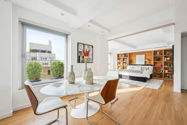 a large kitchen with kitchen island a stove a sink dishwasher a dining table and chairs with wooden floor