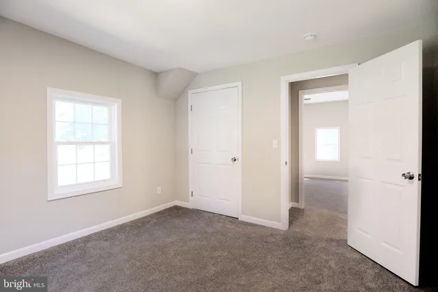 an empty room with windows and closet