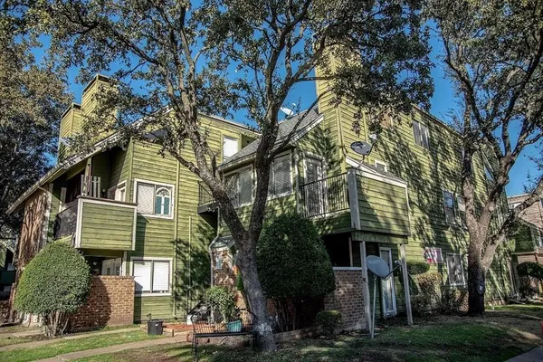 a front view of a house with a tree