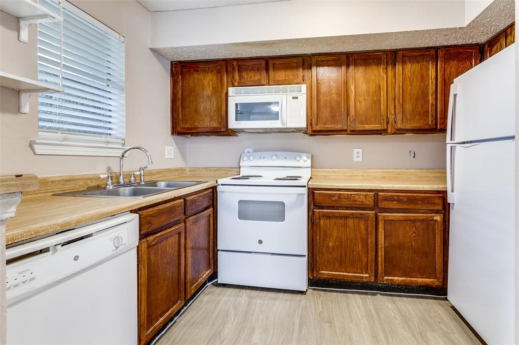 9833 Walnut Street, Unit 203 Dallas, TX 75243 - Photo 7 of 19 a kitchen with a white cabinets and white appliances