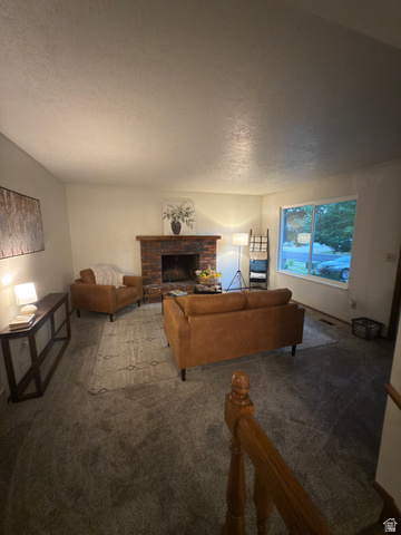 1164 East Mountain Road Logan, UT 84321 - Photo 40 of 45 Living area with textured carpeting, a brick fireplace, and a large window