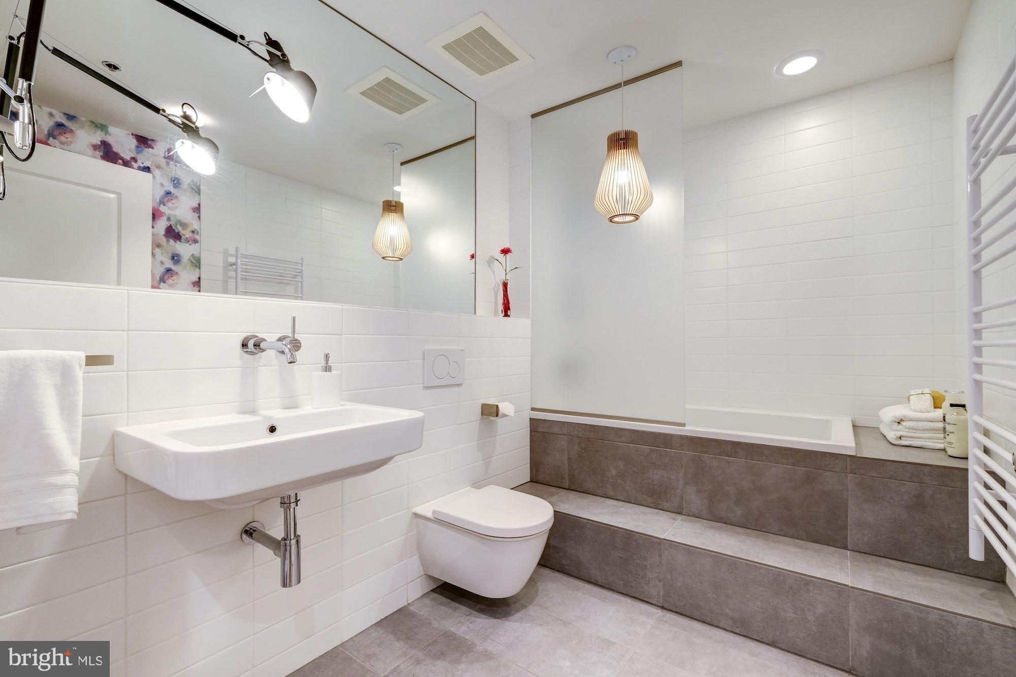 2125 14th Street Northwest, Unit 315W Washington, DC 20009 - Photo 23 of 35 a bathroom with a sink toilet and a mirror