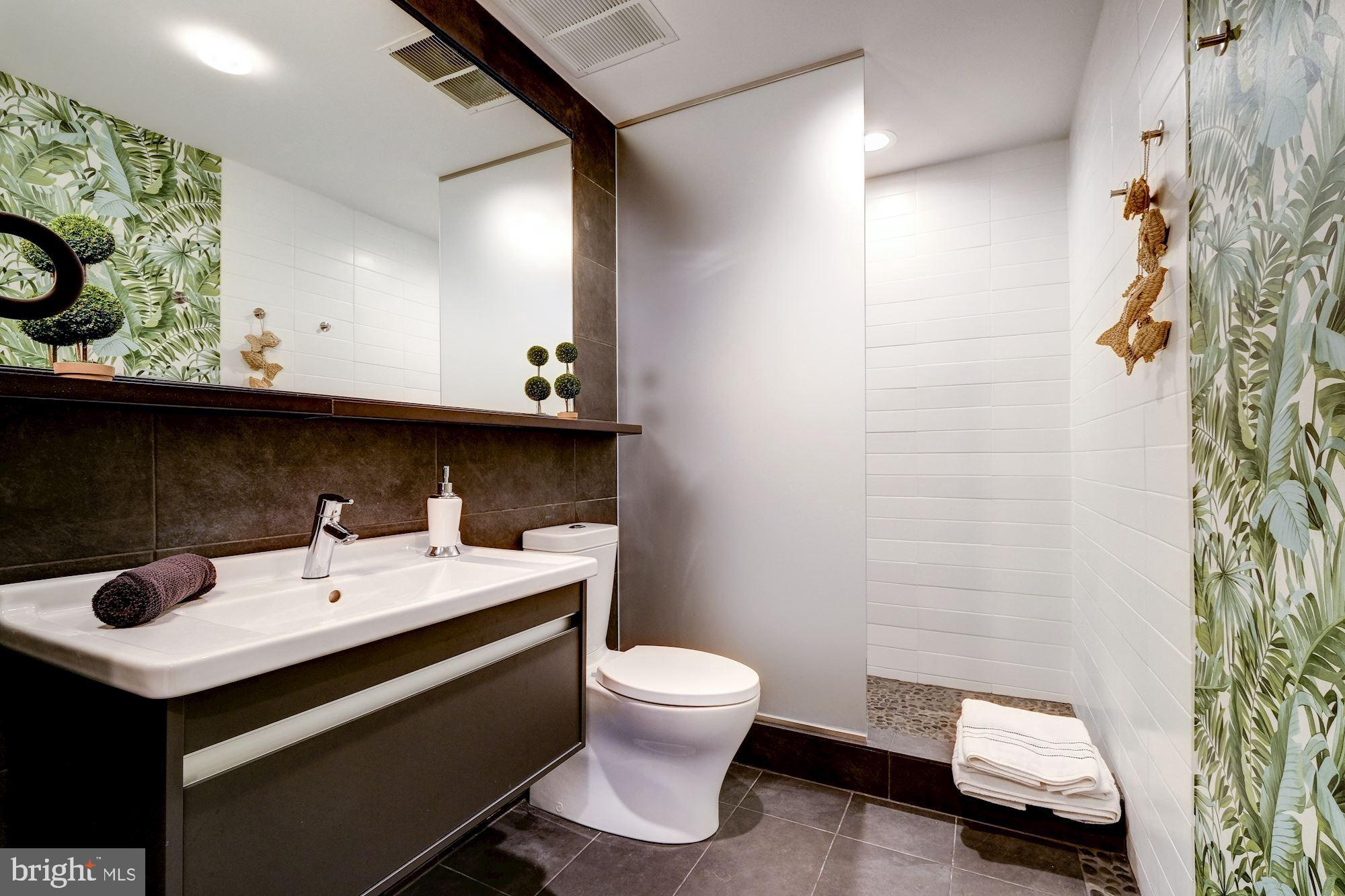 2125 14th Street Northwest, Unit 315W Washington, DC 20009 - Photo 7 of 35 a bathroom with a sink a toilet and shower