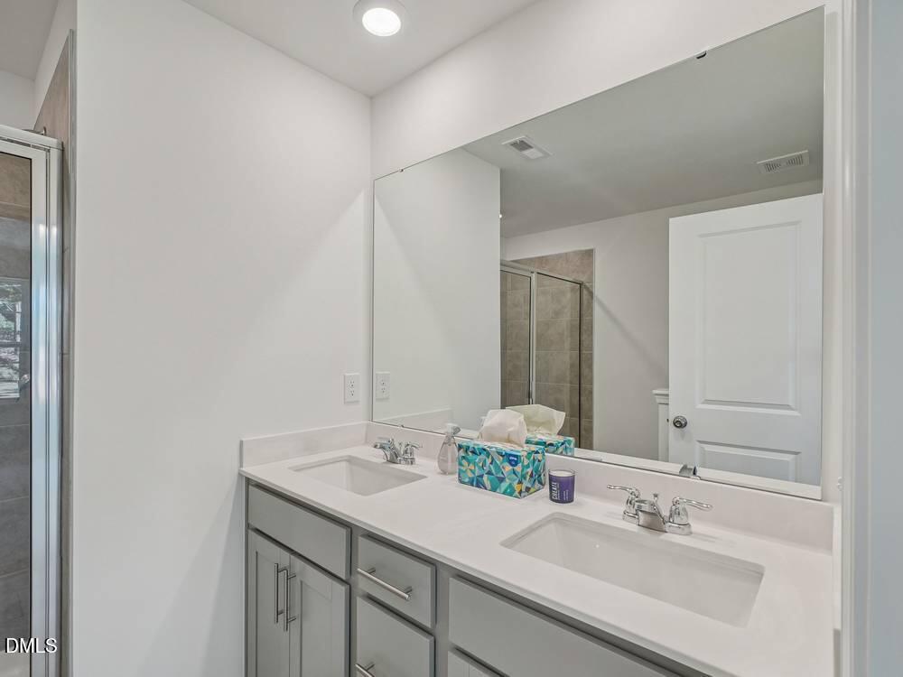 3101 White Blossom Court, Unit SAVANNAH 3103 Raleigh, NC 27610 - Photo 13 of 20 a bathroom with a sink and a mirror