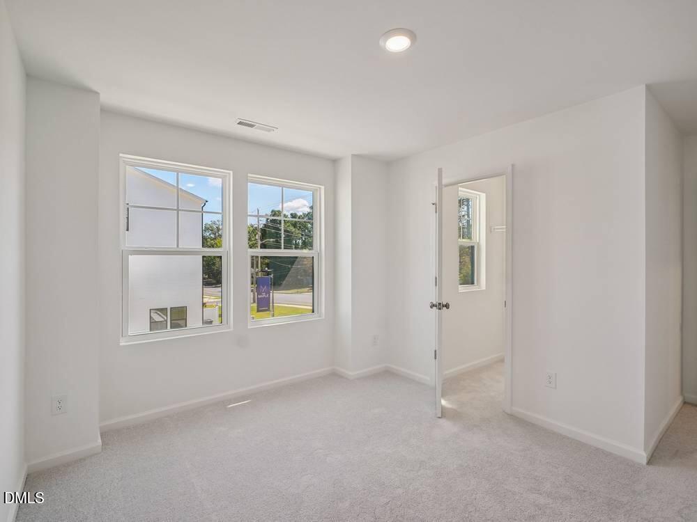 3101 White Blossom Court, Unit SAVANNAH 3103 Raleigh, NC 27610 - Photo 16 of 20 an empty room with windows and closet