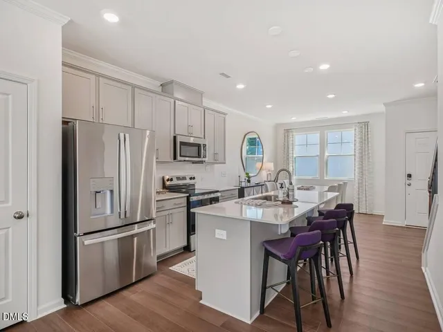 a large kitchen with stainless steel appliances a sink a stove and a refrigerator