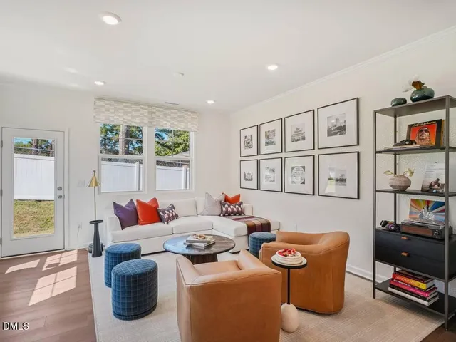 a living room with furniture kitchen view and a wooden floor