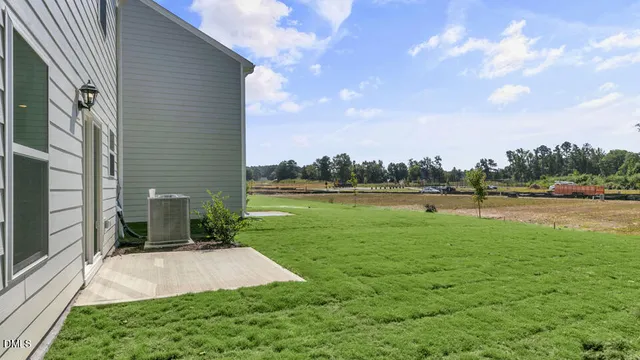 a view of a house with a large window and yard in front of main door