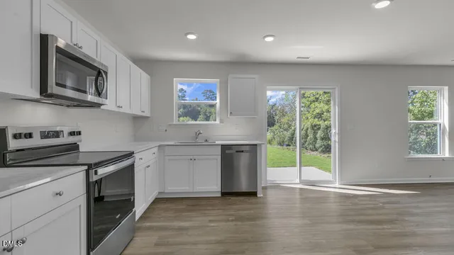 a kitchen with stainless steel appliances granite countertop a stove a sink and a microwave