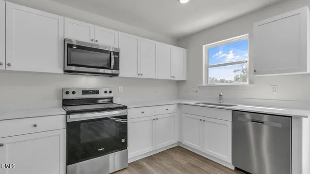 a kitchen with white cabinets and stainless steel appliances